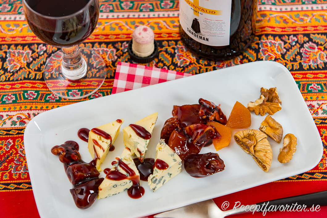 En ostdessert av ädelost, en söt sås/sirap med portvin, nötter och torkad frukt på tallrik med ett glas fruktigt Ruby portvin. 
