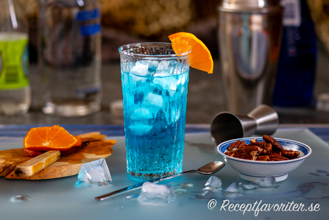 Drinken Isbjörn eller Blue Lagoon i highballglas med rostade pekannötter till. 