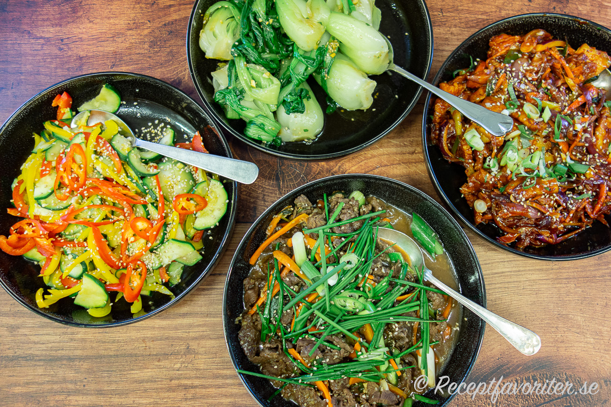 Frästa grönsaker serverade som namul - en grönsaksrätt - tillsammans med bok choy, fläsk i gochujang och bulgogi biff. 