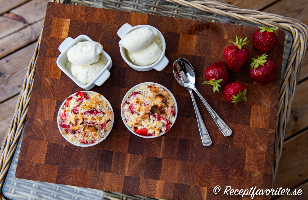Två portioner jordgubbsgino i formar serverade med vaniljglass. 