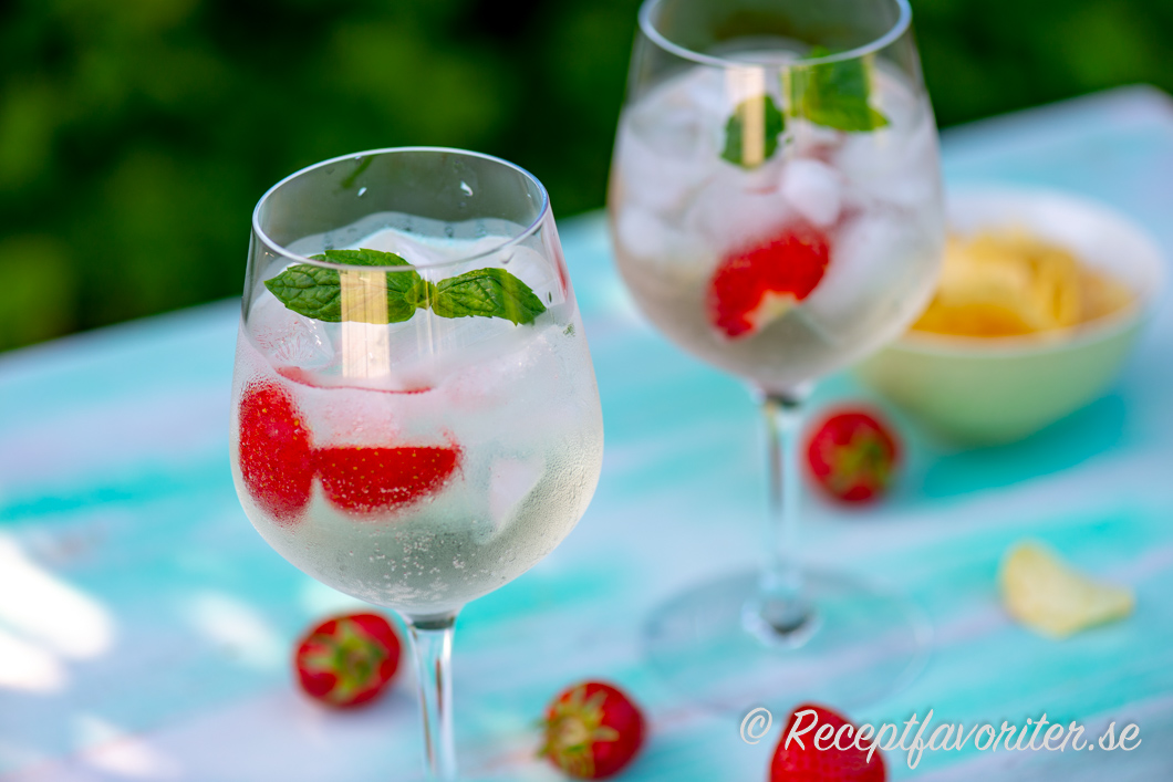 En cocktail eller drink med Lillet Blanc, tonic water, is, jordgubbar och mynta. 
