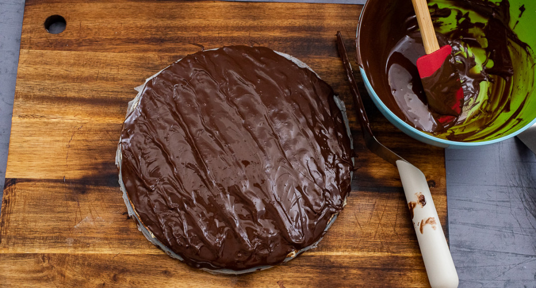 Toppa med ca 4/5 av chokladen och gör gärna lite vågigt mönster med spatel eller slickepott. 