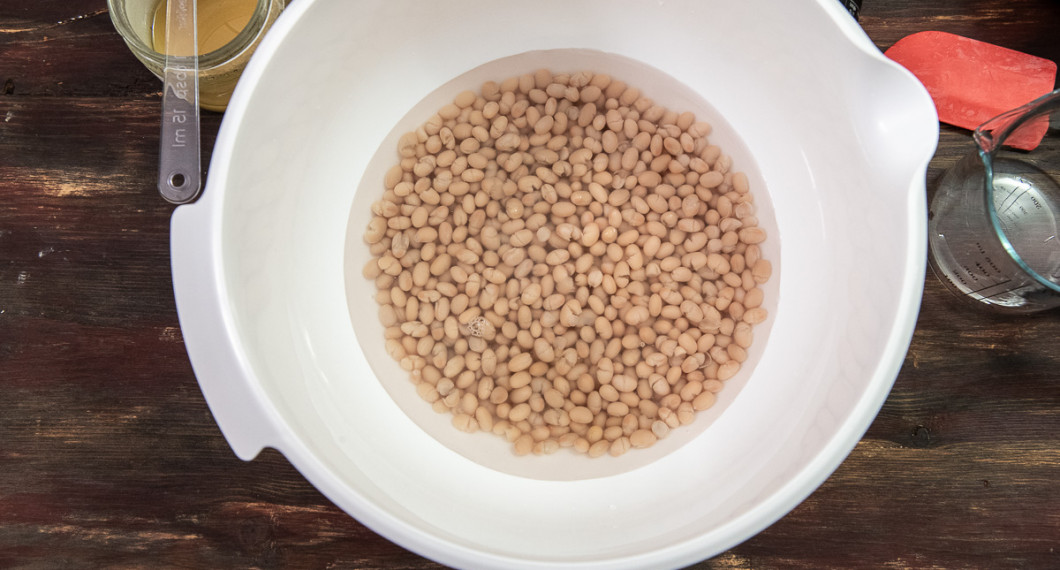 Mät upp bönor och vatten i en stor degbunke. 