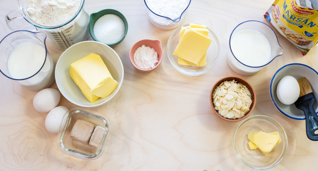 Ingredienser till butterkakan: vetemjöl, mjölk, ägg, jäst, smör och socker till deg. Vaniljsocker, smör och florsocker till fyllning 1. Mjölk och vaniljsåspulver till fyllning 2. Mandelspån, ägg samt smör. 