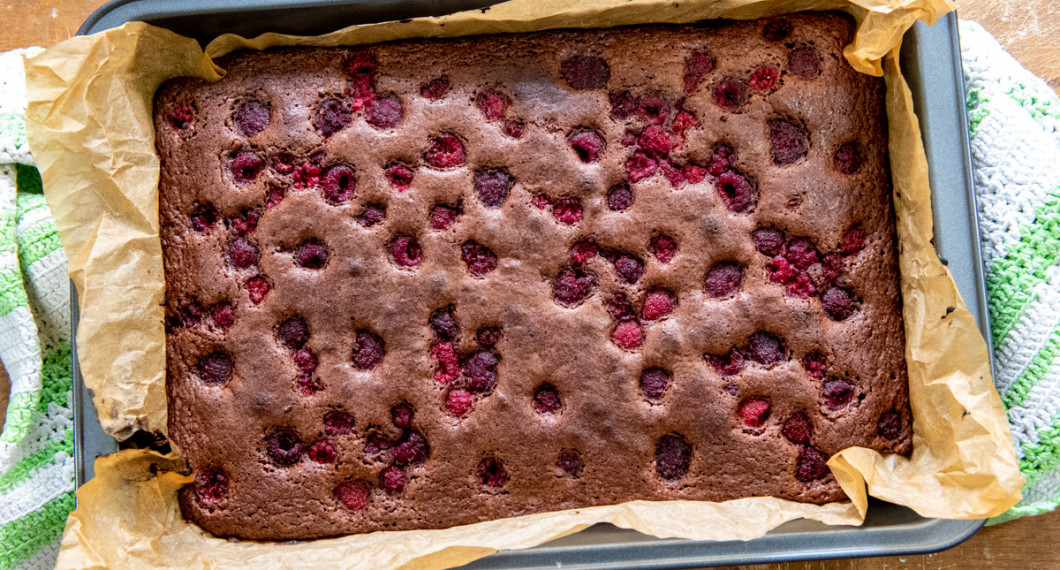 Choklad- och hallonkakan gräddas tills den får färg och hallonen sjunker ner i kakan. 