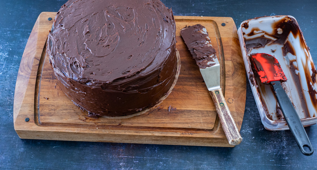 På och runt hela tårtan breds chokladglasyren. 