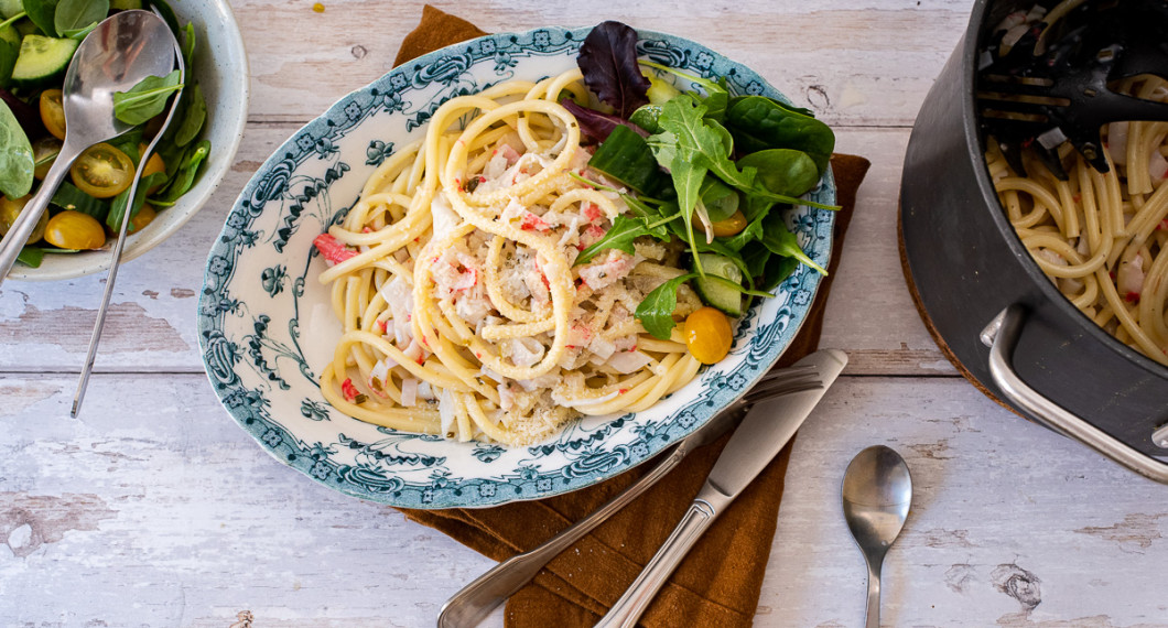 Servera pastan med en grönsallad, gurka och tomat samt lite riven ost på toppen. 