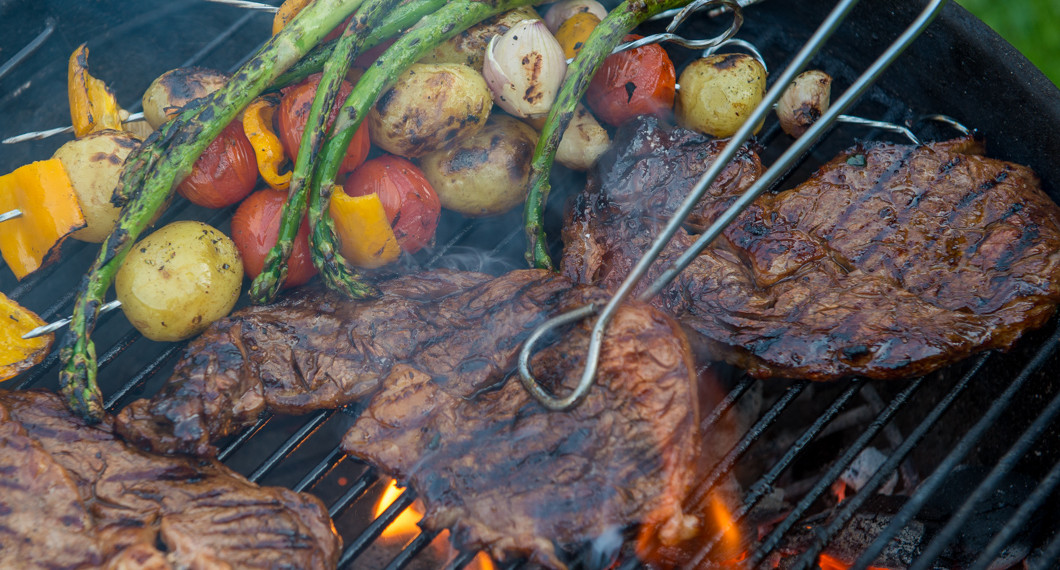 Entrecote grillas på utegrill med grönsaker