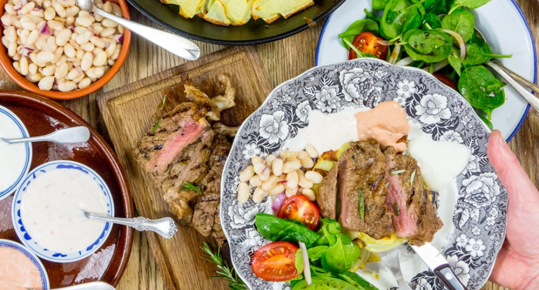 På bilden är den ugnsrostade potatisen serverad till kött (grillad entrecote) samt en spenat- och tomatsallad, marinerade vita bönor samt tre kalla såser.