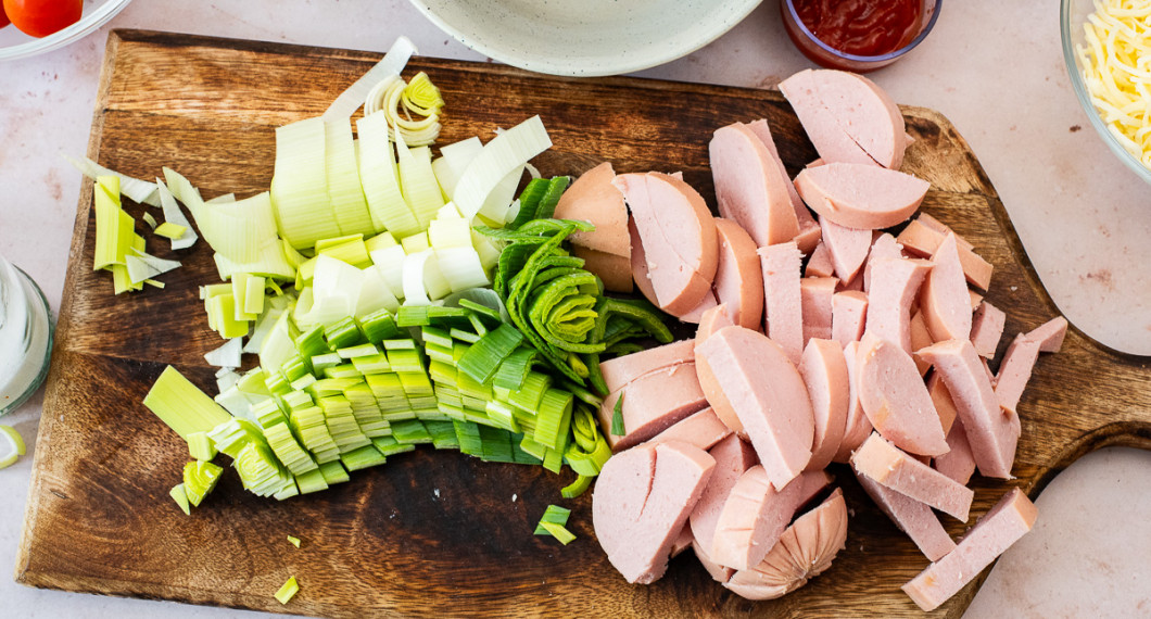 Skölj och strimla purjolök samt skär falukorv i stavar eller bitar. 