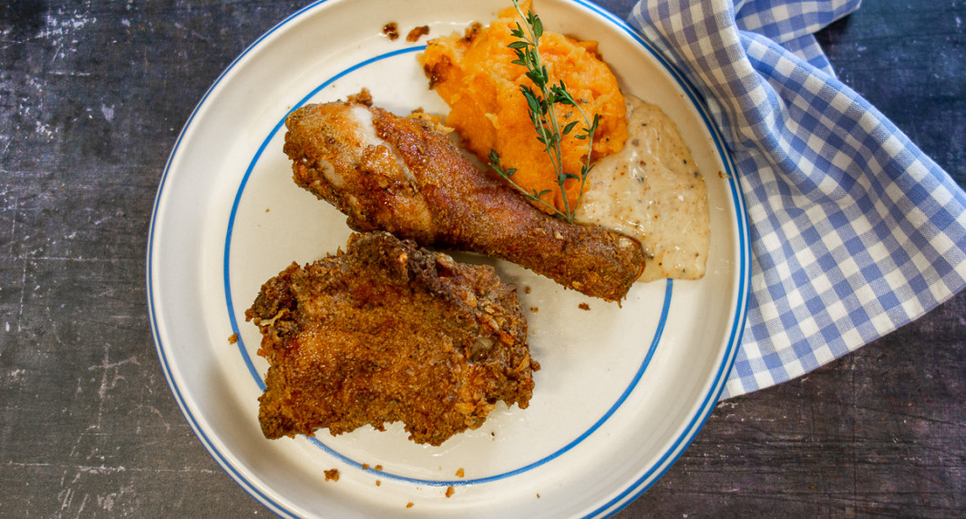 En tallrik med friterad kyckling, sötpotatismos och chipotlemajonnäs. 