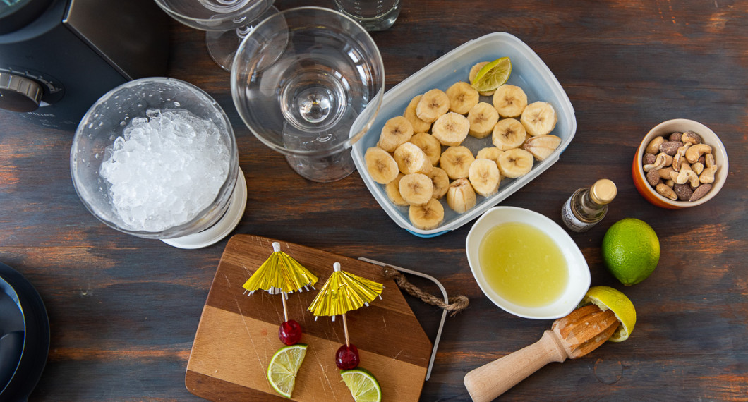 Ingredienser till den alkoholfria banandaiquirin: krossad is, sockerlag, Sprite, ljus romessens, fryst banan, färskpressad lime och garnering med lime, cocktailbär och paraply. 