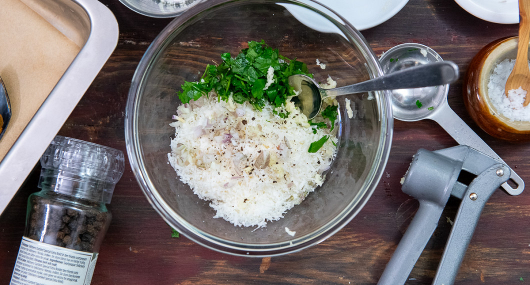 Lägg riven parmesan, ströbröd, hackad schalottenlök samt pressad vitlök i en skål. 