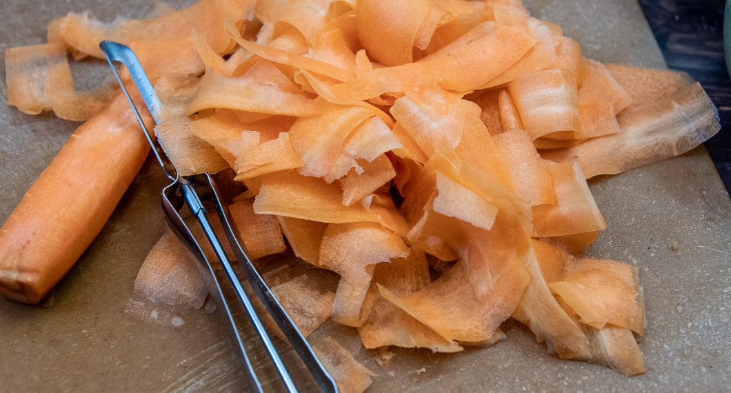 Skala morötterna och skär dem med en potatisskalare i tunna strimlor. 