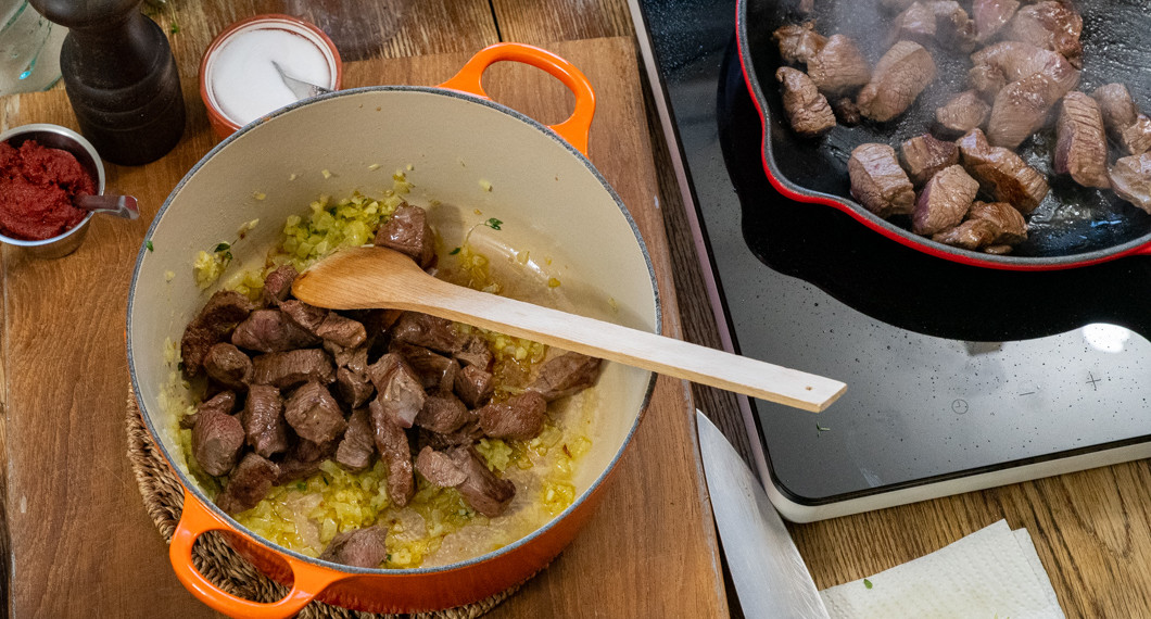 Hjortköttet bryns och läggs över i grytan med löken efter hand