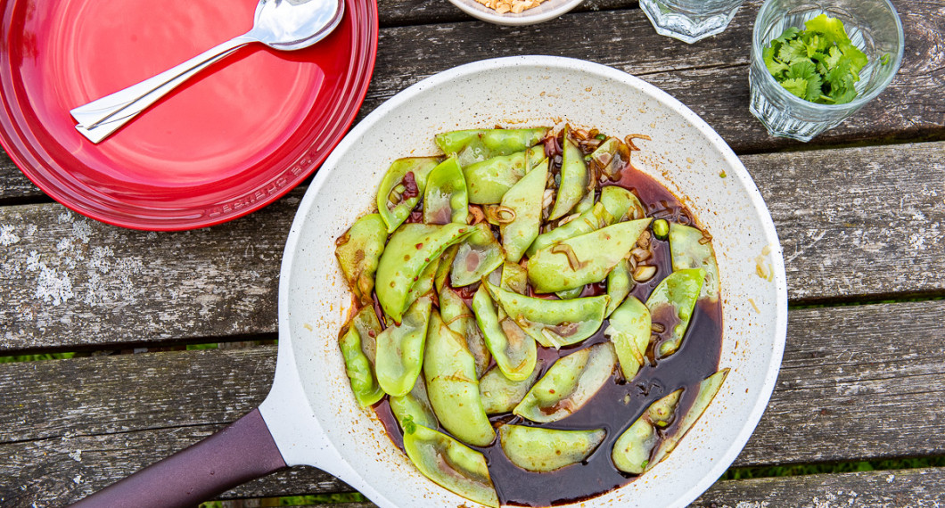 Ärtorna smaksätts i stekpanna eller wok med sojamarinaden och toppas med jordnötter och färsk koriander. 