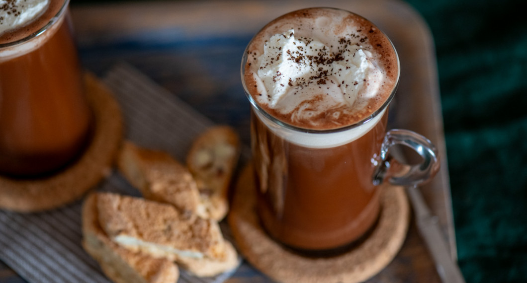 Tillsätt rom och häll upp i Irish coffee-glas samt toppa med lättvispad grädde och kaffepulver. 