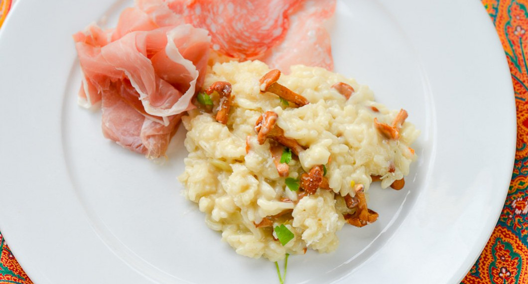 Risotto med kantareller serverade med lufttorkad italiensk skinka prosciutto samt salami. 