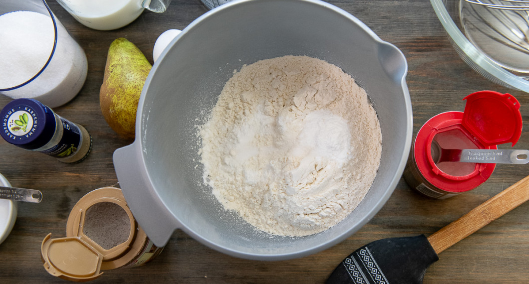 Mät upp och blanda vetemjöl, bakpulver, salt och kardemumma i en bunke. 