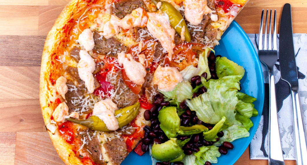 En variant på kebabpizza med skivad tomat, vitlöks- och chilisås och en grönsallad till. 