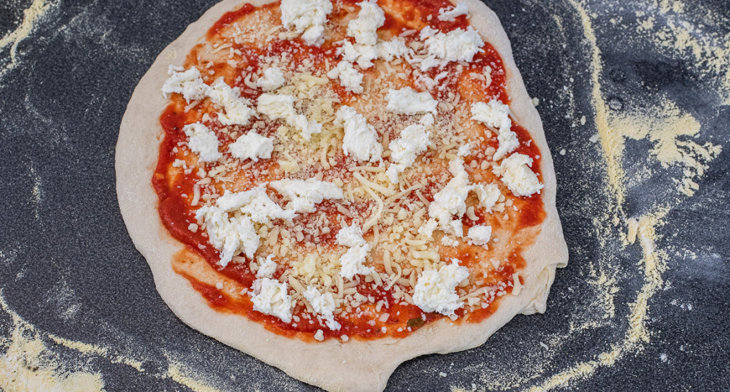 Bred först ut pizzasås. Sedan riven mozzarella och grovt delad färsk mozzarella. 