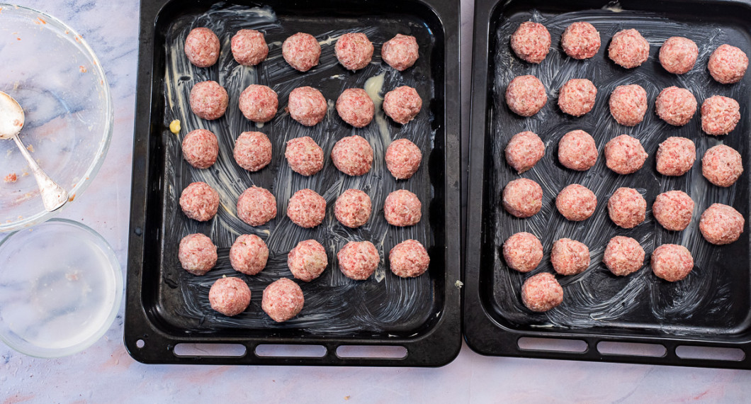 Rulla köttbullar och lägg med några cm mellanrum i två smorda ugnsplåtar. 