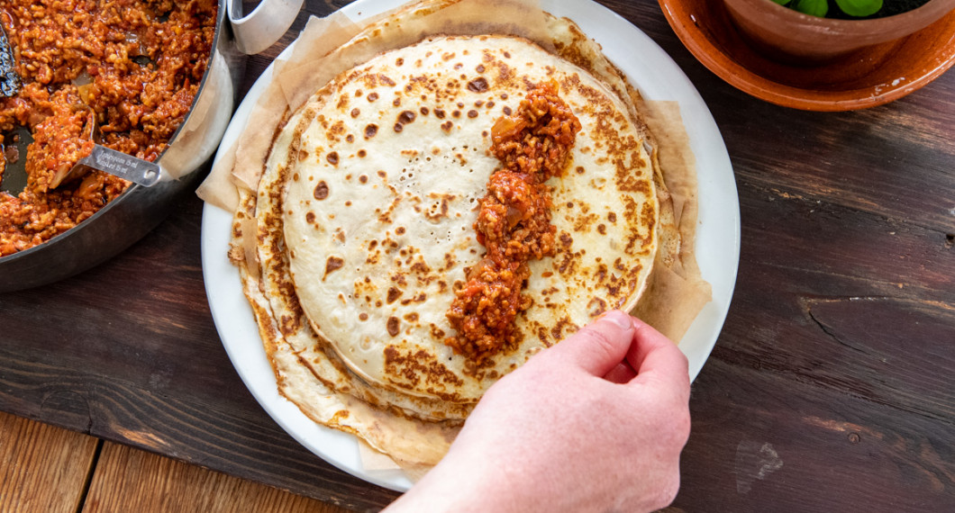 Lägg 3-4 msk köttfärsröra i högra kanten på varje pannkaka samt rulla ihop. 