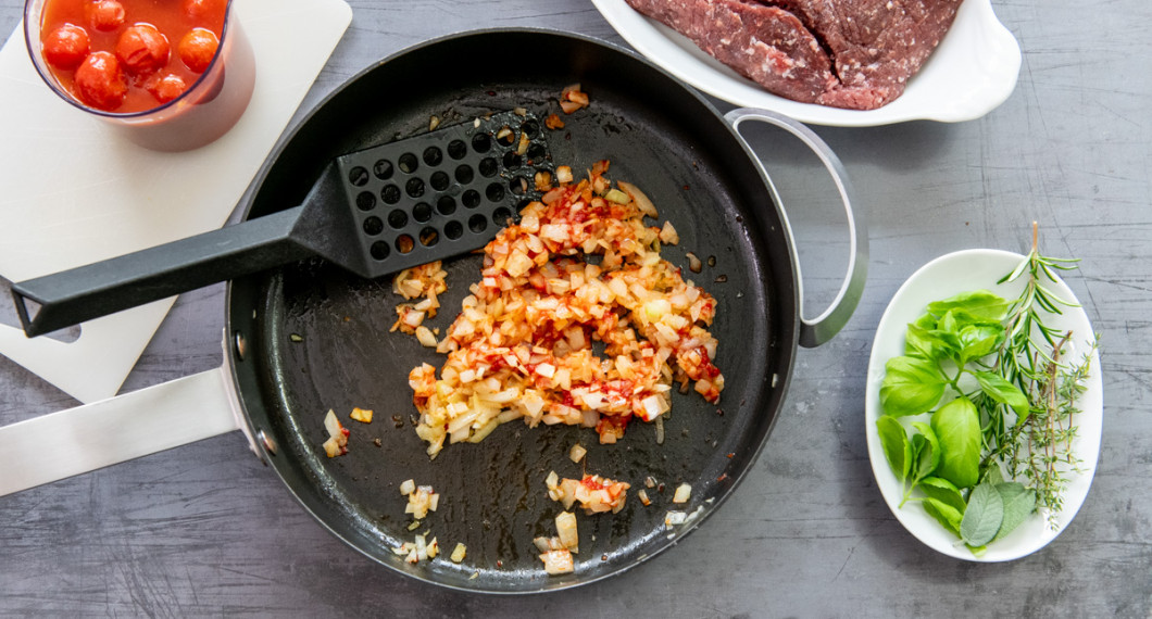 Hackad gul lök, vitlök, tomatpuré och chili fräses i olivolja och smör. 