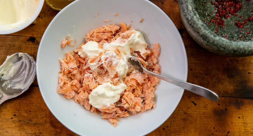Dela den varmrökta laxen i bitar. Blanda med crème fraiche och pressad citron. 
