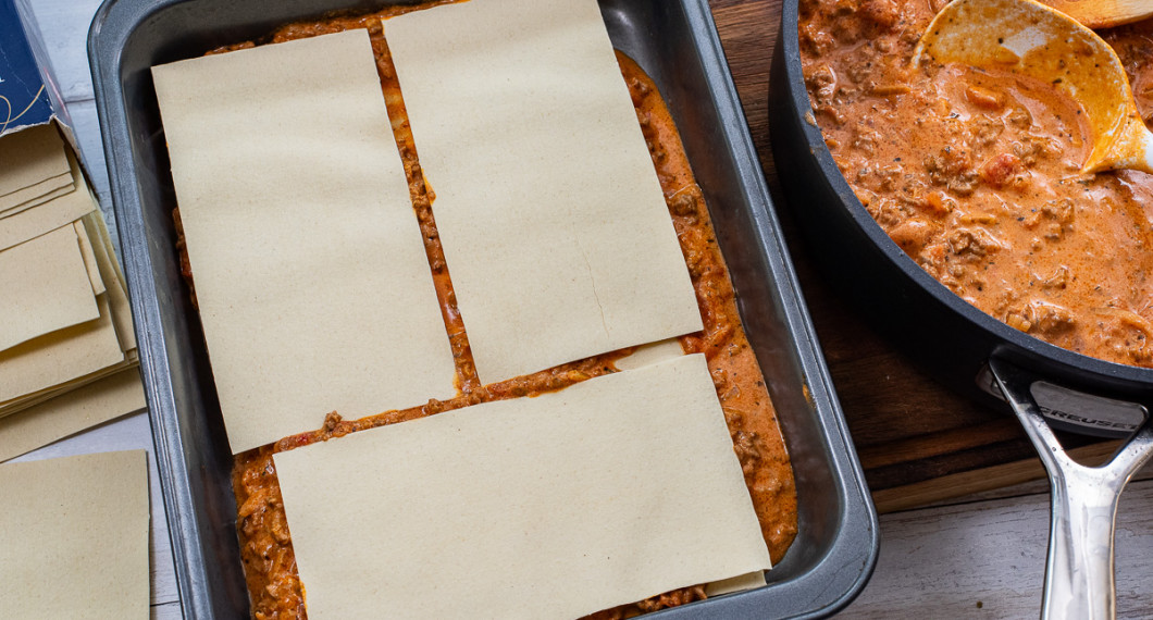 Lasagneplattor och sås varvas.