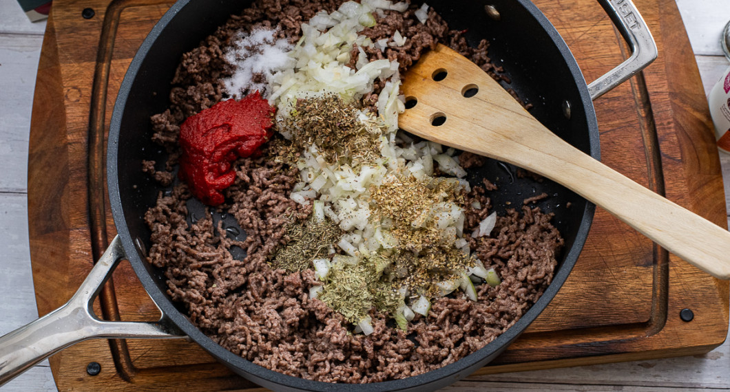 Tillsätt tomatpuré, hackad lök och vitlök, oregano, timjan, rosmarin, dragon, basilika, salt och peppar.