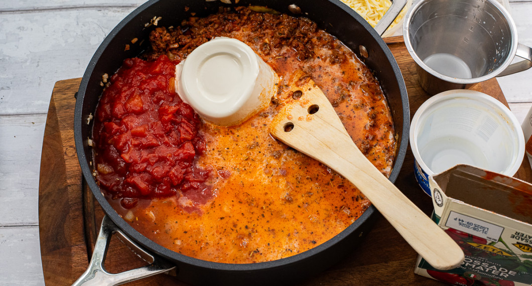 Tillsätt vatten, mjölk, crème fraiche och krossade tomater.