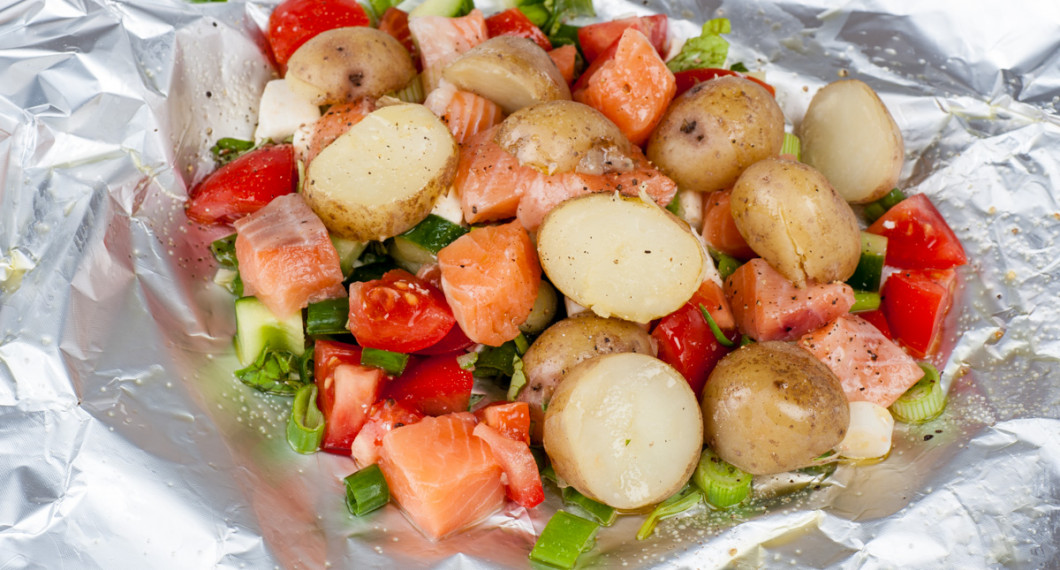 Lägg tärnad rå lax, kokt potatis samt alla ingredienser på ett folieark och vik ihop till ett paket. 