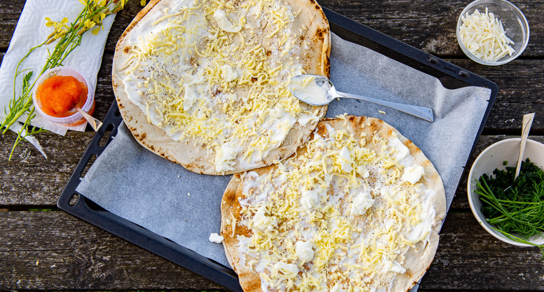 Libabröden förbereds med crème fraiche, riven mozzarella, färsk mozzarella samt toppingen av löjrom, ruccolablommor, pecorino, dill och grönkål. 