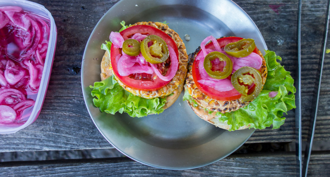 Lägg på 1-2 skivor tomat, picklad rödlök samt jalapenos efter tycke. Bred hamburgerdressing på översta brödet och lägg ihop. 
