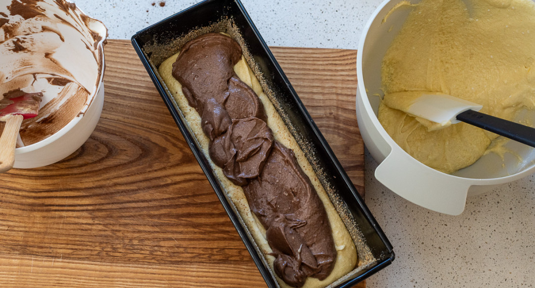 Bred ut hälften av den ljusa smeten i botten på formen. Lägg sedan all chokladsmet i ett lager över.  