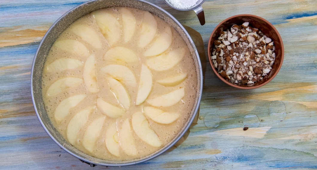 Häll smeten en smord och bröad springform samt fördela äppelklyftorna överst. 