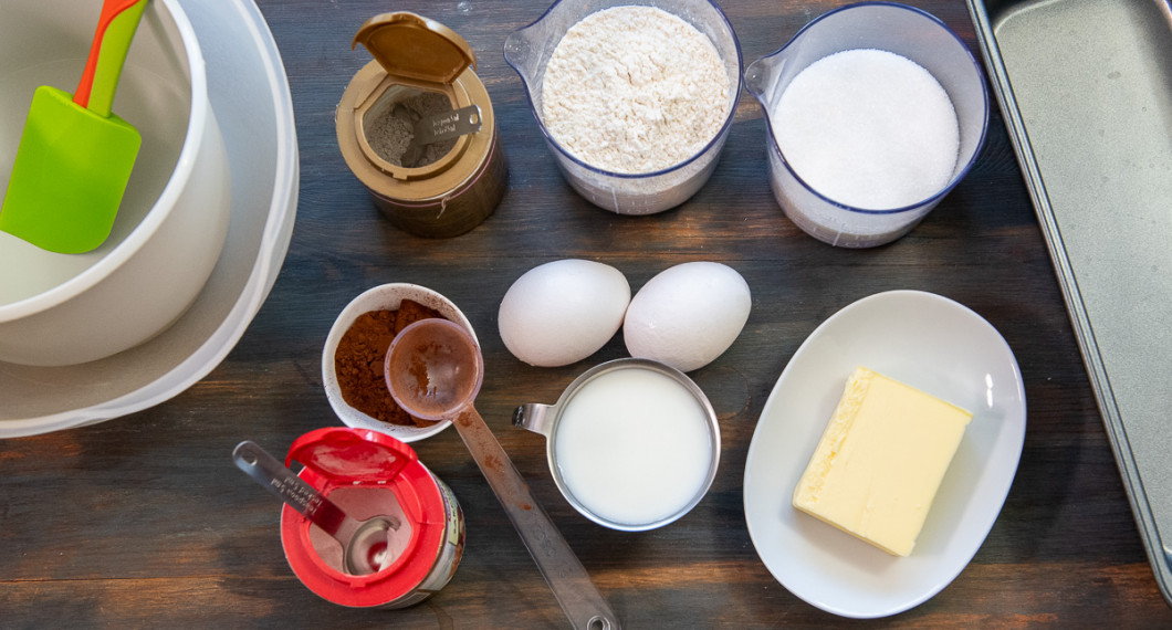Till chokladkakan behöver du vaniljsocker, kakao, bakpulver, vetemjöl, ägg, mjölk samt smör. Utanför bild salt. 