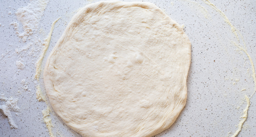 Knåda ut pizzan med händerna. Använd durumvetemjöl.  