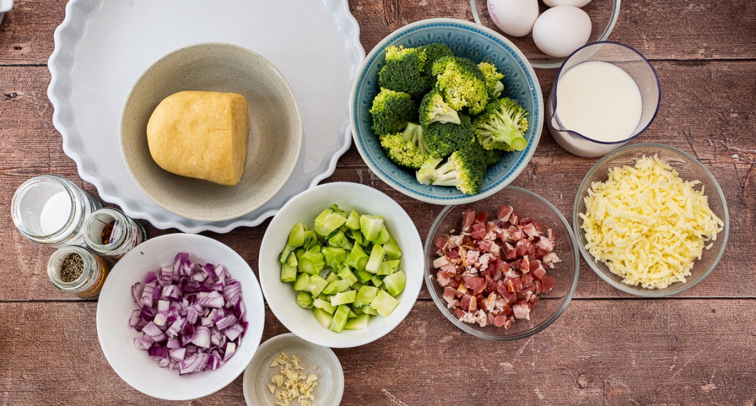 Till pajen behöver du pajdeg, salt, peppar, chiliflakes, rödlök, vitlök, broccoli, bacon, ägg, mjölk och riven ost. 
