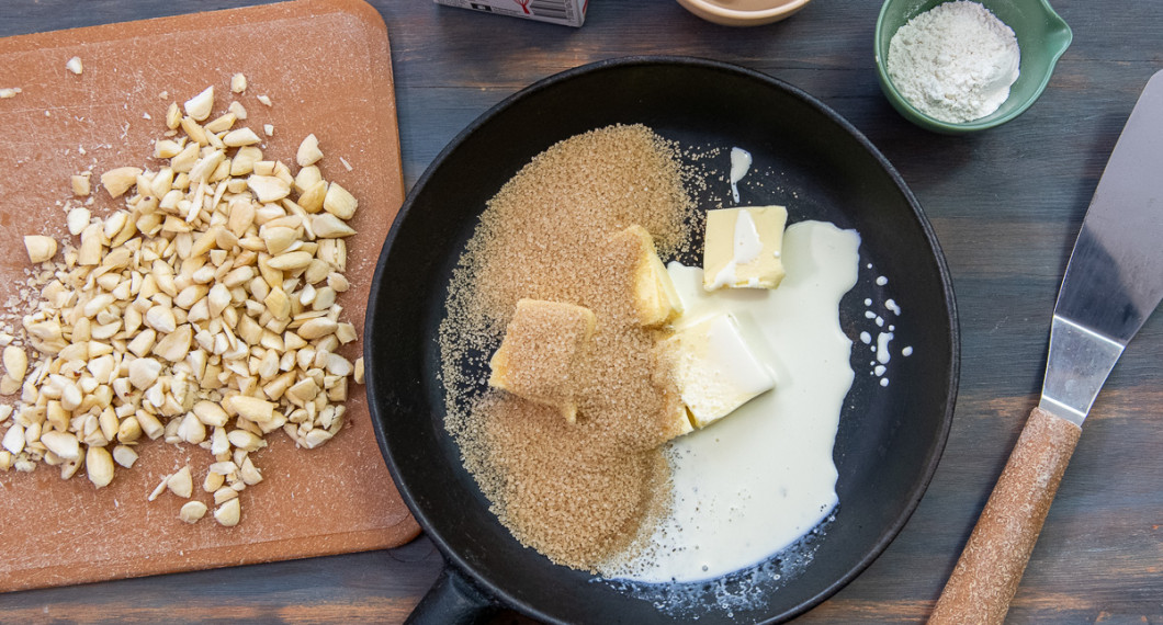 Börja med toscasmeten. Skålla, skala och hacka mandel. Mät upp smör, socker och grädde i en stekpanna. 