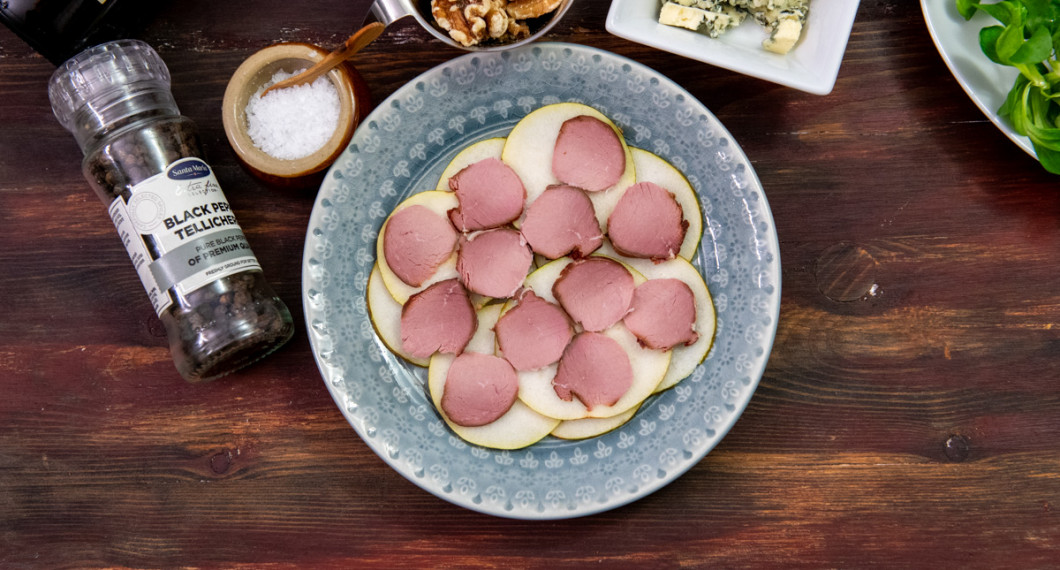 Fördela tunt skivat rökt kött över päronen. 