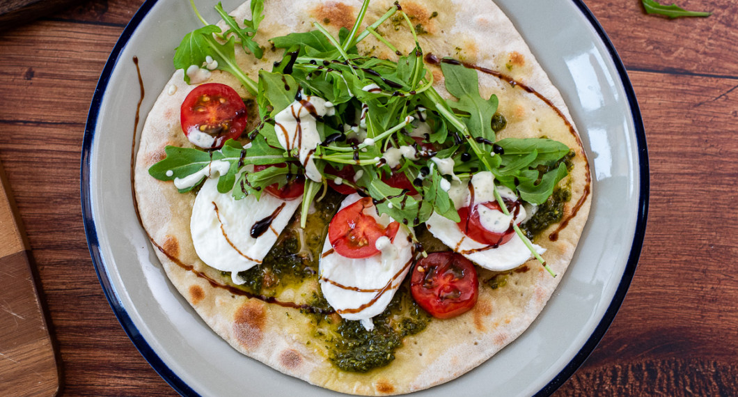 Piadina som vegetarisk smörgås med pesto, mozzarella, tomat, ruccola, basilikakräm och balsamico. 