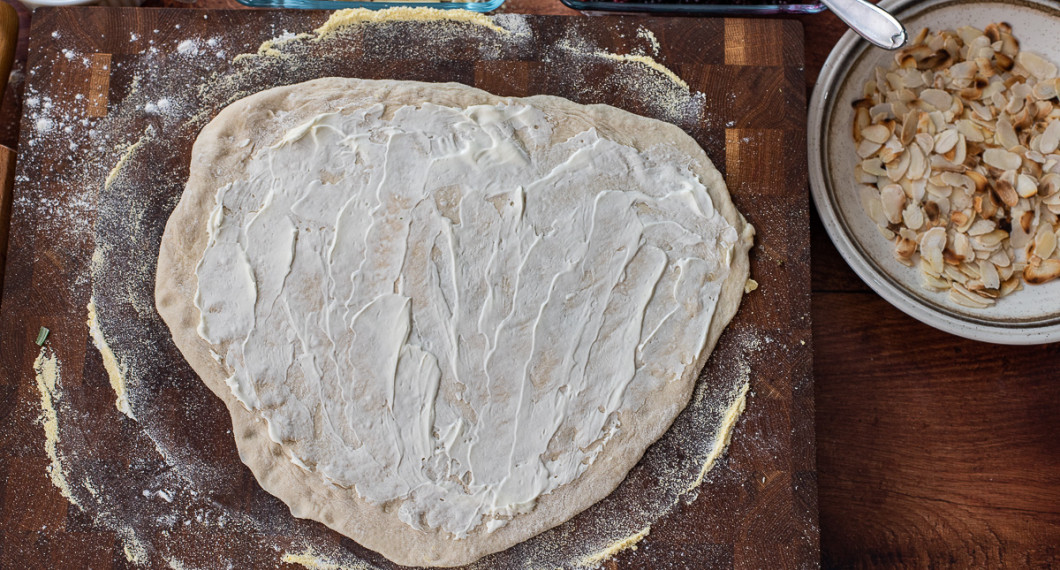 Bred först ut ett lager crème fraiche och grädda sedan pizzan. 