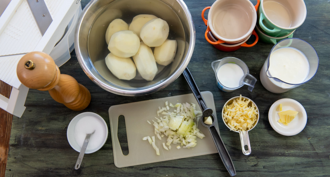 Till gratängerna behöver du skalad potatis, vitpeppar, salt, gul lök, vitlök, grädde, mjölk och riven ost. 