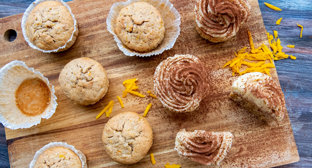 Pumpamuffinsen garneras med frosting, pudrad kakao och riven pumpa. 