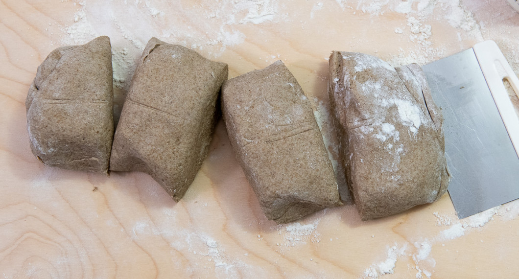 Knåda ihop degen på mjölat bakbord och dela i fyra delar. 