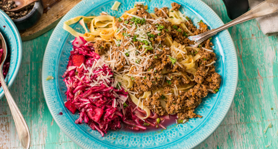 Servera köttfärsragun med tagliatelle och parmesan. Den röda råkostsalladen är valfri till men god.