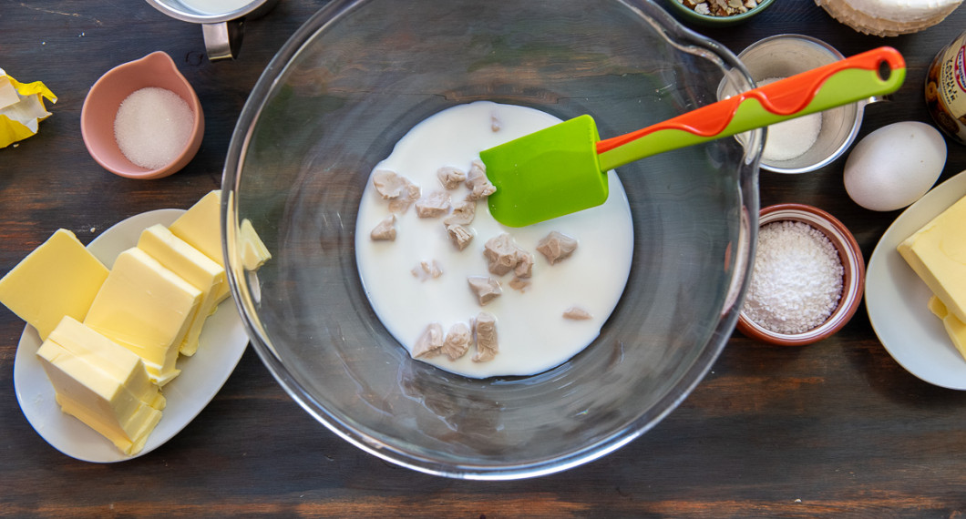 Smula ner jästen i kall mjölk i en stor degbunke. Rör tills jästen löst sig. 