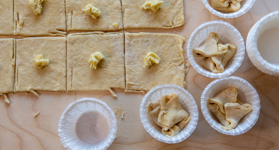 Kavla ut degen och skär i fyrkanter. Lägg en klick fyllning på varje och vik upp hörnen till ett knyte. 